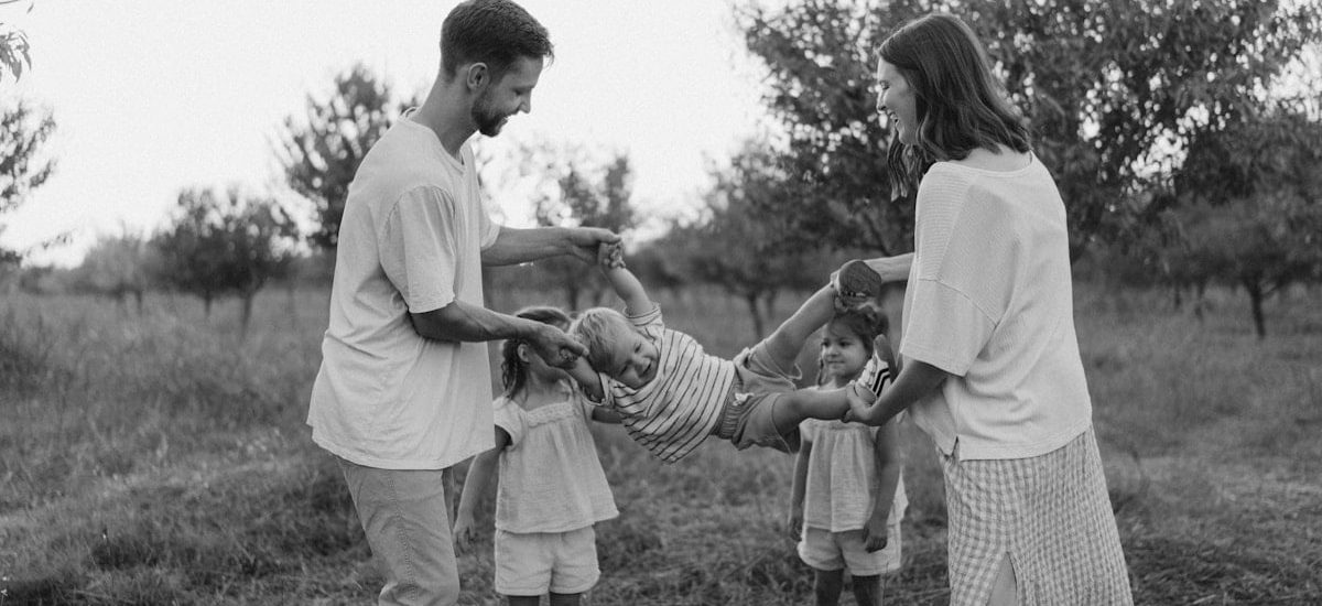 Family playing with child in grassy field