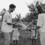 Family playing with child in grassy field